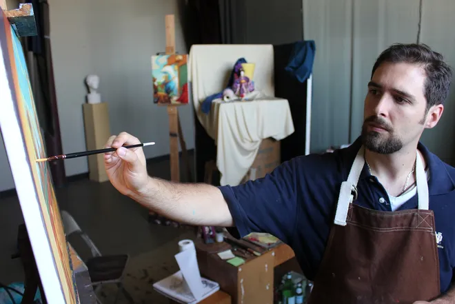 John Folley painting in his studio